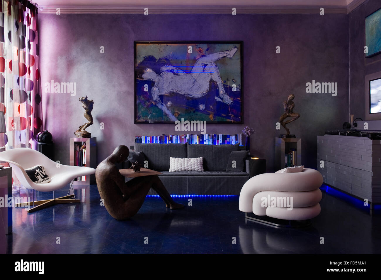 Art moderne au-dessus de canapé avec des meubles dans le néon allumé appartement à Londres Banque D'Images