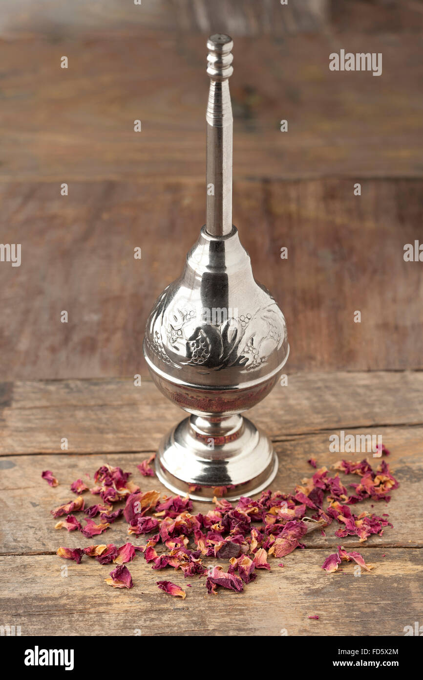 L'eau de rose marocaine et les pétales sprinkleur sur table en bois Banque D'Images