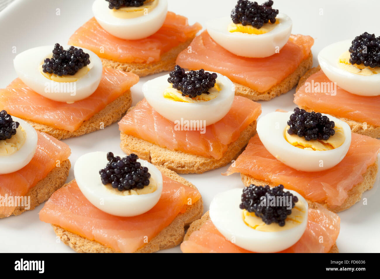 Snack avec du saumon, des oeufs de cailles et de lompe sur toast Banque D'Images