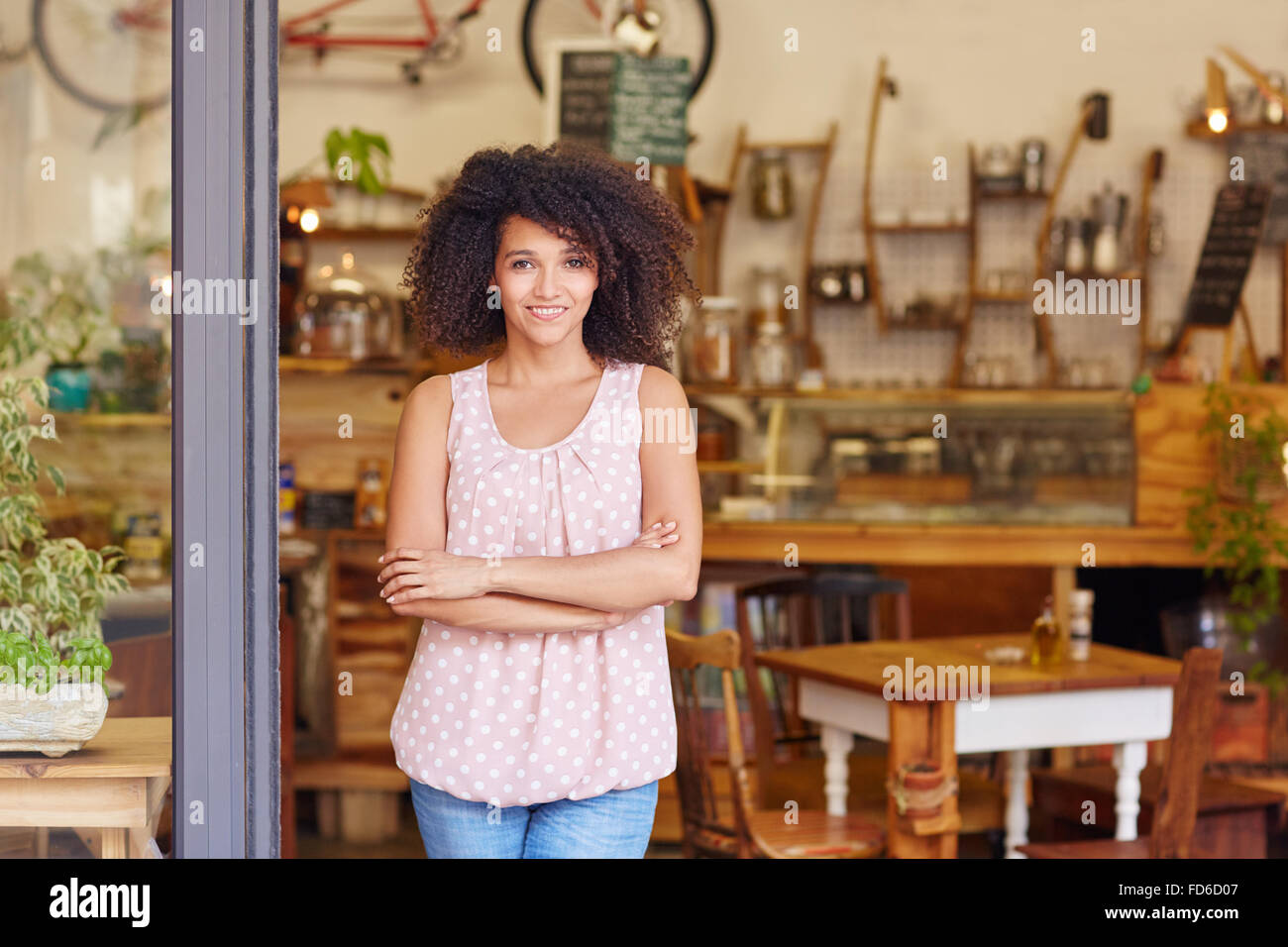 Propriétaire de petite entreprise debout dans la porte de son café Banque D'Images