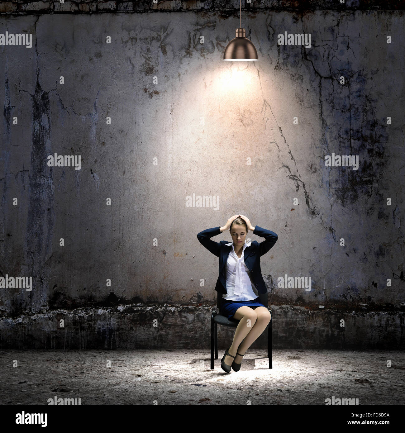 Image de young businesswoman sitting on chair sous tache de lumière Banque D'Images