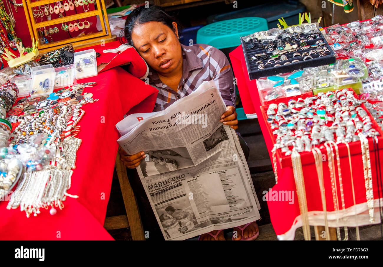 Femme au marché un marché bazar à Ubud, lisant le journal, les lecteurs de journaux en Asie, scène de rue, Ubud, Bali, Indonésie, Asie Banque D'Images