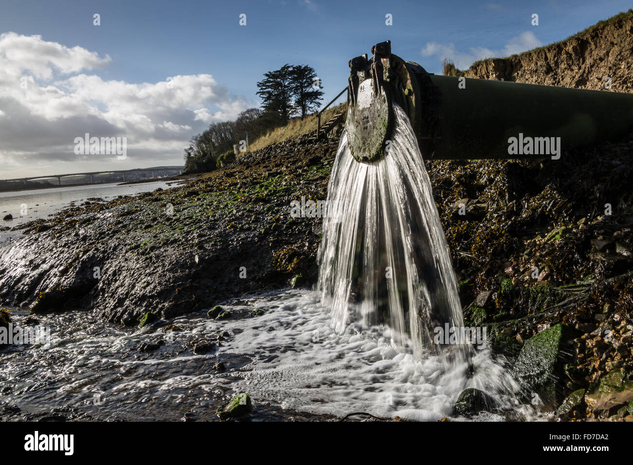 L'eau s'écoule des déchets d'une sortie du tuyau d'eau de déchets dans la rivière dans le Devon UK Banque D'Images