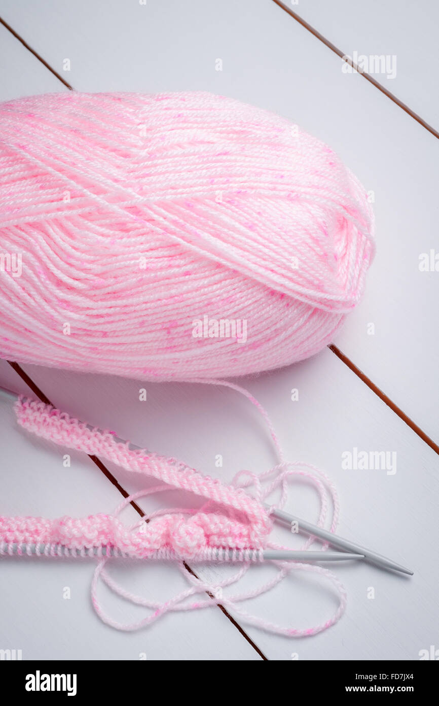Aiguilles à tricoter et une pelote de laine rose un concept d'aiguille à tricoter ou Banque D'Images