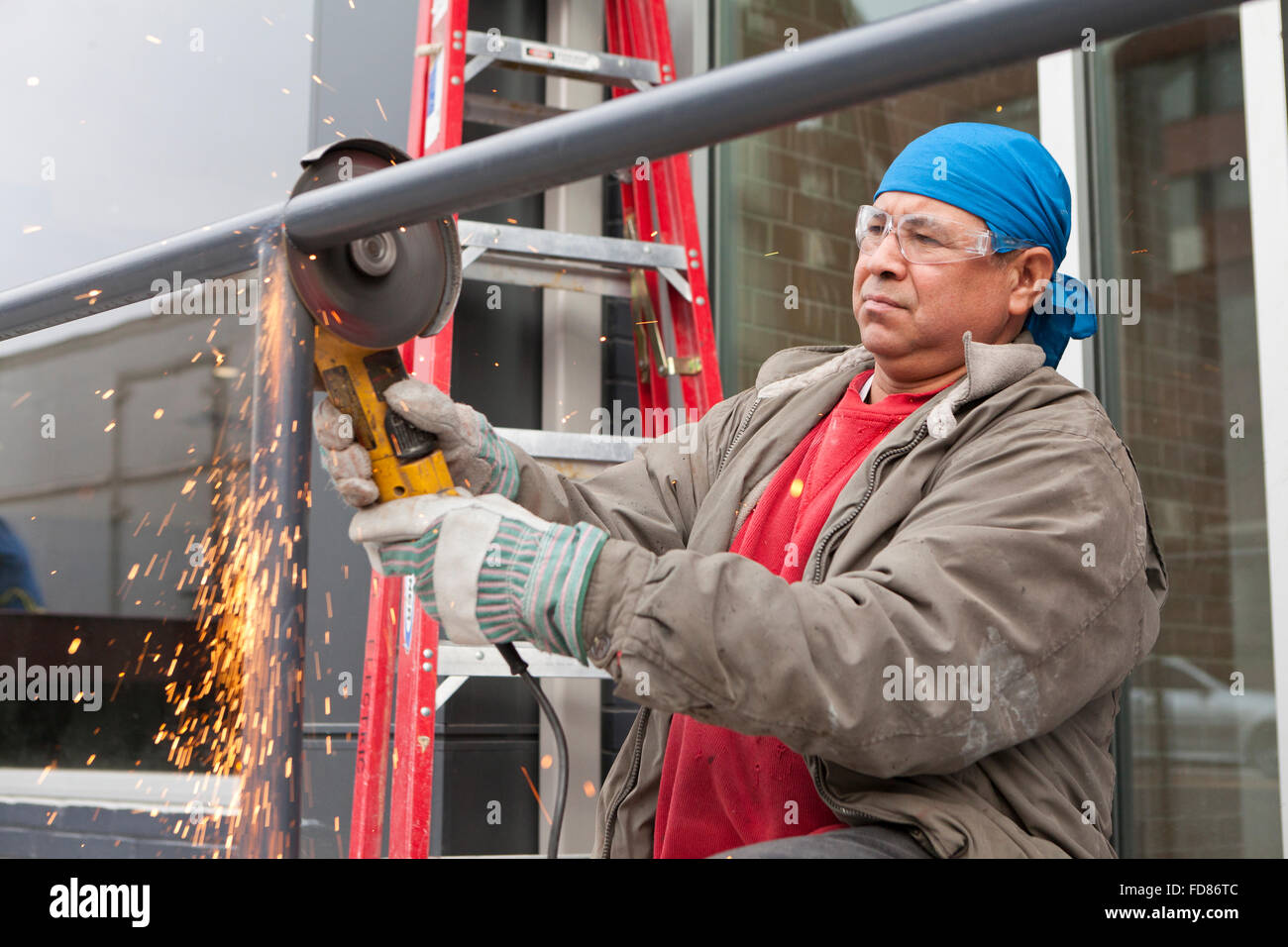 Construction Worker cutting steel pipe avec outil Meuleuse angulaire - USA Banque D'Images