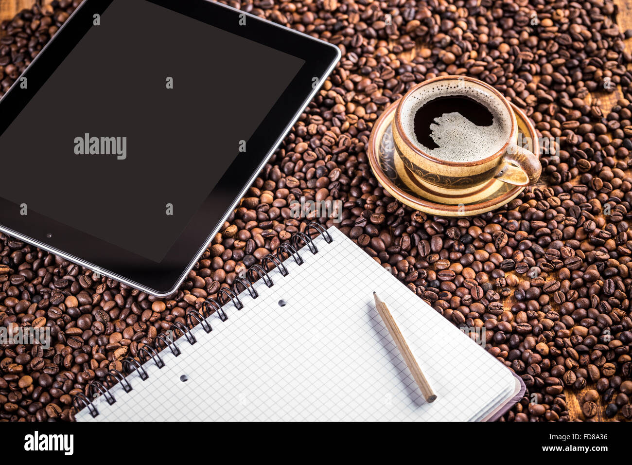 Tablette numérique, papier et sur les grains de café tasse de café contexte Banque D'Images