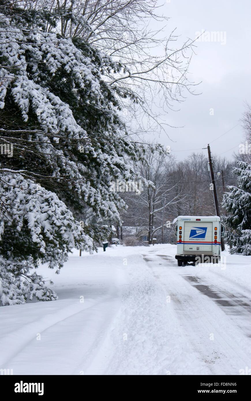 Un camion postal livrer le courrier dans un quartier dans la neige. Banque D'Images