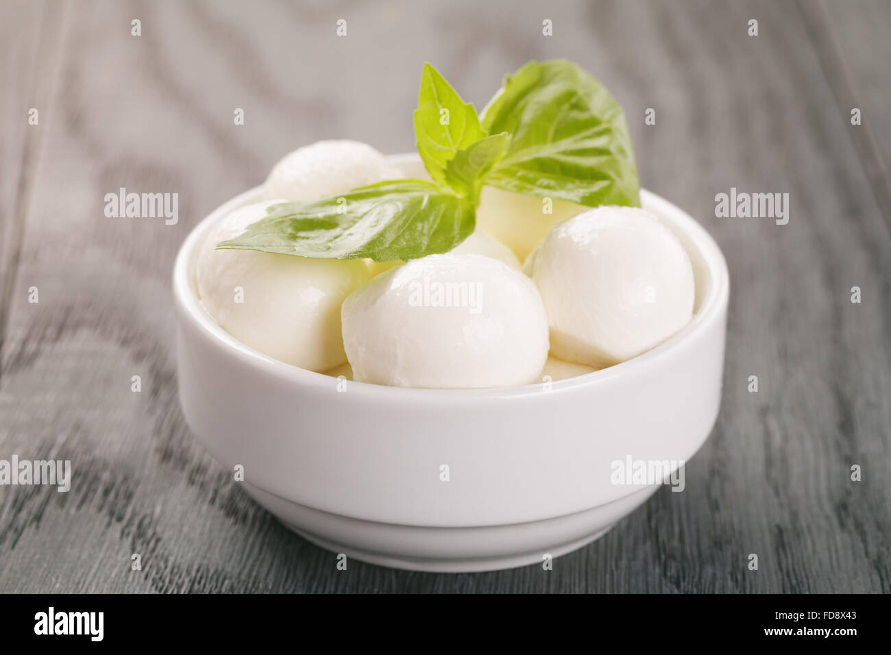 Petites boules de mozzarella au basilic dans un bol Banque D'Images