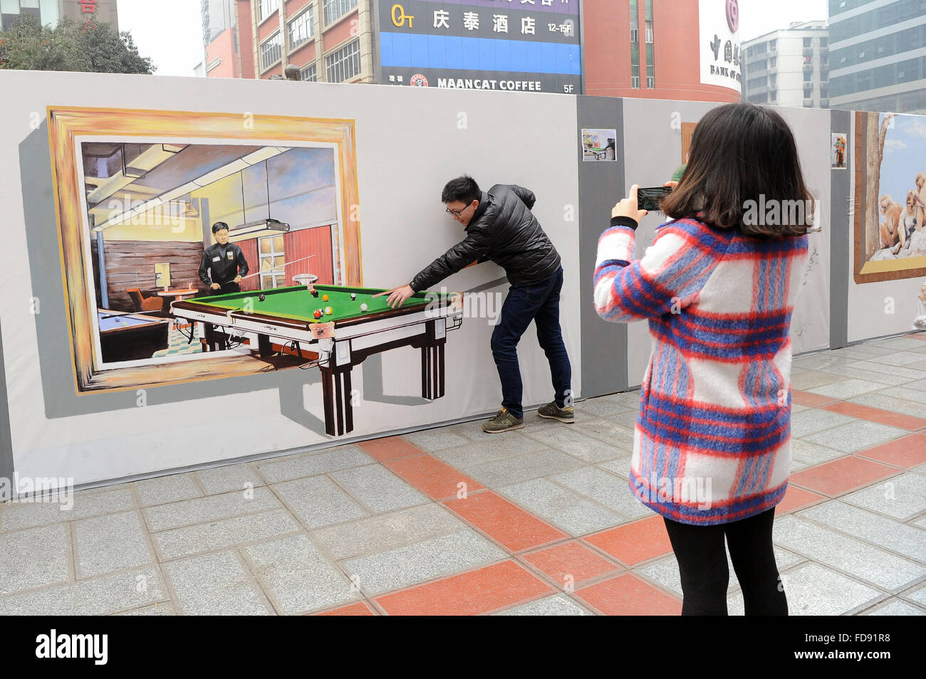 Chongqing, Chine. 29 janvier, 2016. Les citoyens prennent des photos avec un trompe-l'œil au carré Sanxia à Chongqing, au sud-ouest de la Chine, le 29 janvier 2016. En trompe-l'oeil est un art technique qui utilise des images pour créer l'illusion d'optique qui décrit les objets existent en trois dimensions. © Tang Yi/Xinhua/Alamy Live News Banque D'Images