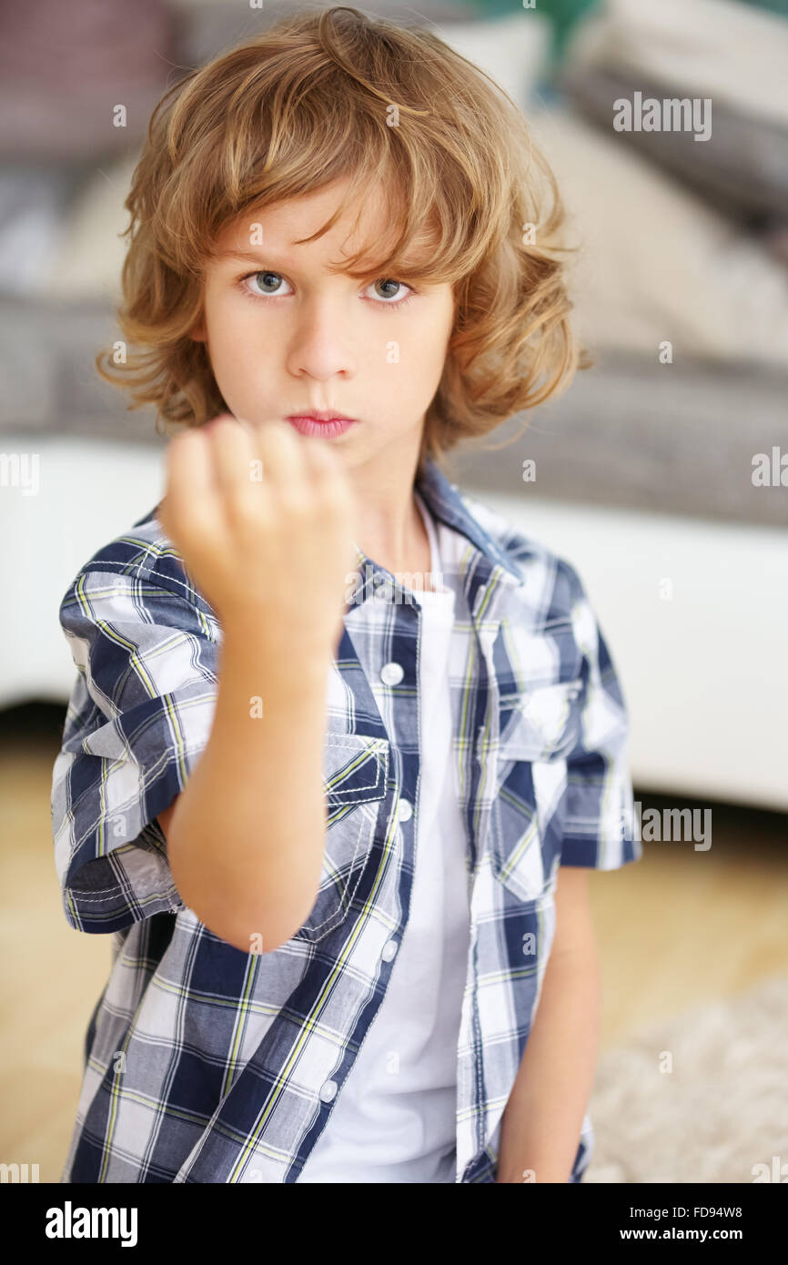 Angry boy élever son poing à la maison Banque D'Images
