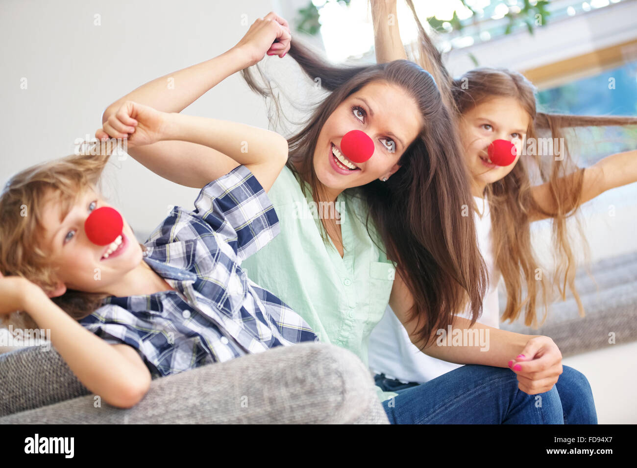 Mère et enfants avec nez rouge s'amusant à la maison Banque D'Images