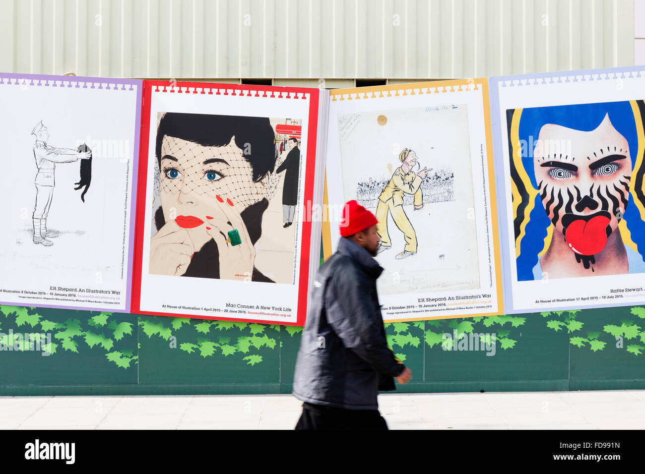 Un homme portant un bonnet rouge hat promenades par un Mac Conner poster au réaménagement de King's Cross à Londres, en Angleterre. Banque D'Images