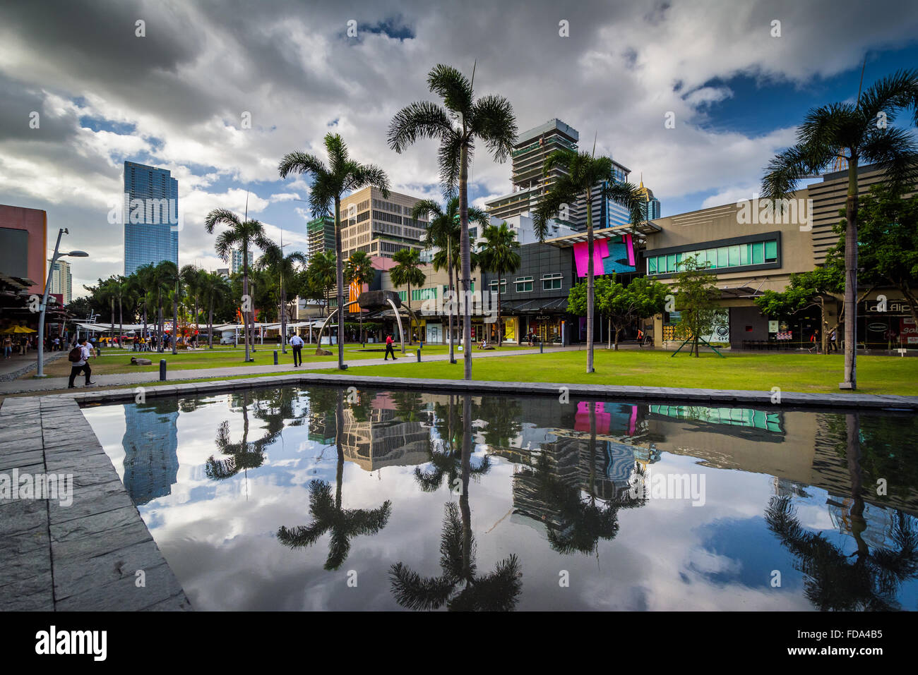 Palmiers et bâtiments modernes reflétant dans une piscine à Bonifacio Global City, à Taguig, Metro Manila, Philippines. Banque D'Images