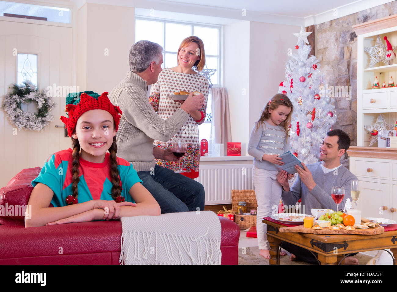 Trois Génération de la famille au moment de Noël. Jeune fille est à la recherche à l'appareil photo et souriant alors que le chat de la famille dans le backgrou Banque D'Images