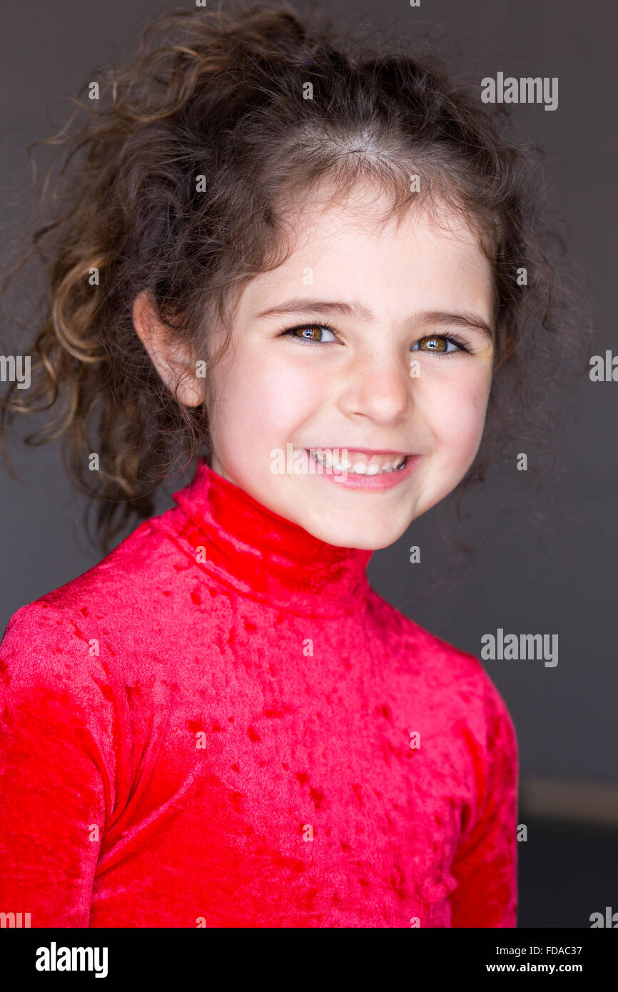 Portrait d'une jeune fille avec un fond gris. Elle porte un justaucorps et souriant à la caméra. Banque D'Images