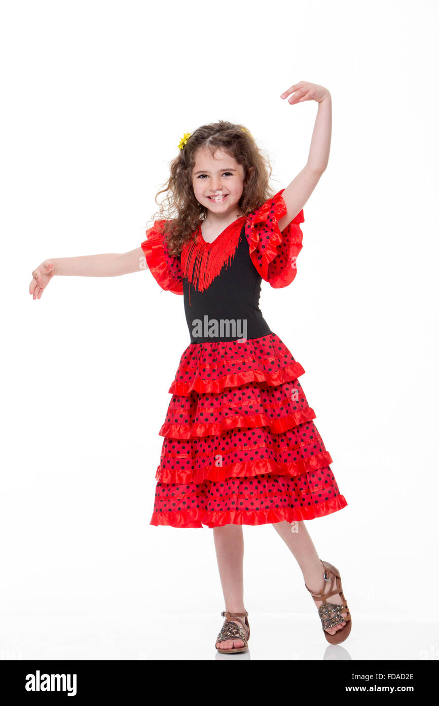 Portrait d'une jeune fille portant un costume flamenco sur un fond blanc. Elle sourit à la caméra. Banque D'Images