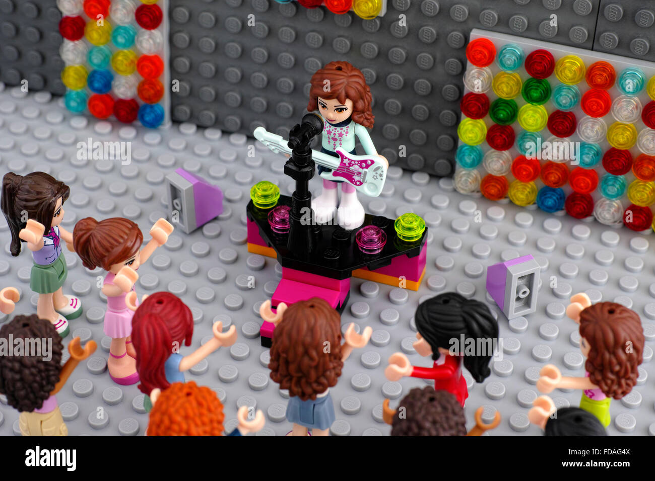 Les concerts de lego avec le musicien et le public. Fille d'amis Lego playmobil - 5116 - moto avec guitare électrique sur la scène avec microphone. Banque D'Images