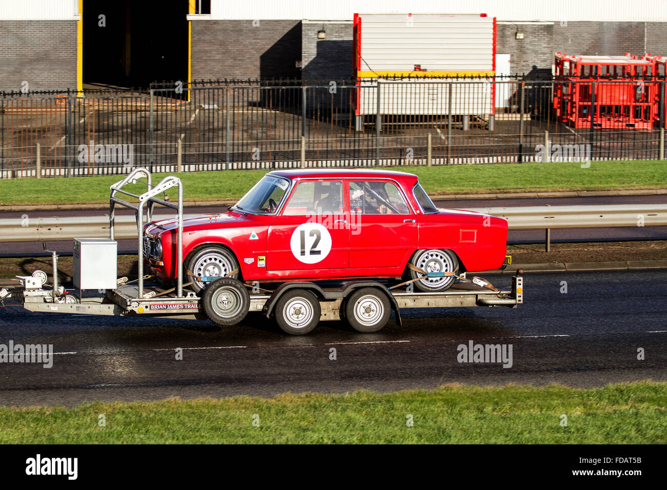 Une Alfa Romeo rouge 'numéro 12' course automobile Stock remorqué sur une remorque le long de la route à l'ouest de Kingsway à Dundee, Royaume-Uni Banque D'Images