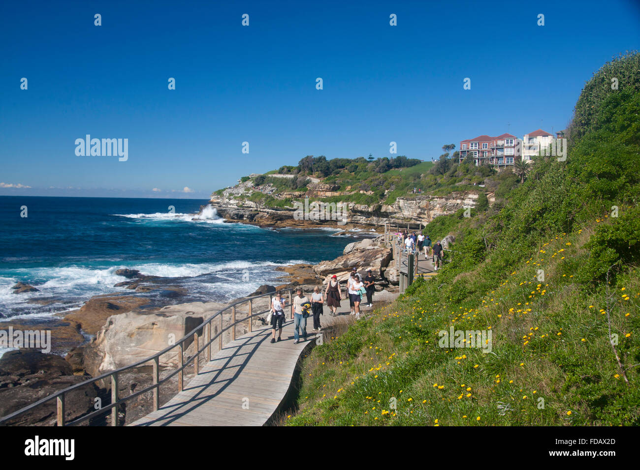 Les promeneurs sur Bondi à Coogee promenade côtière avec en arrière-plan Point MAckenzies Sydney NSW Australie Banque D'Images