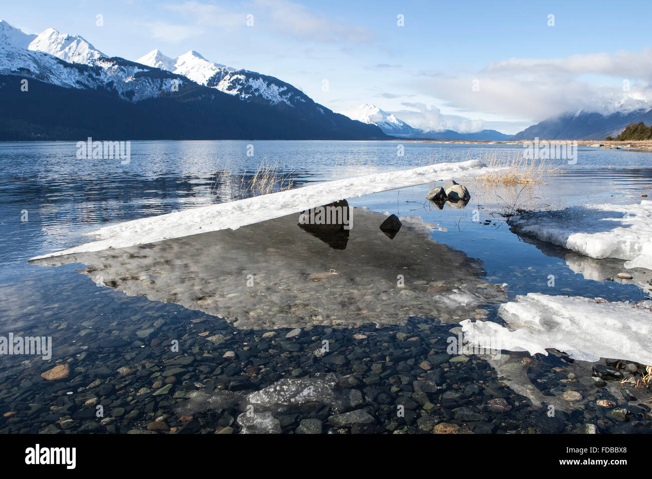 Plaque de glace en équilibre sur un rocher comme la marée basse sur une plage de l'Alaska du Sud-Est en hiver. Banque D'Images