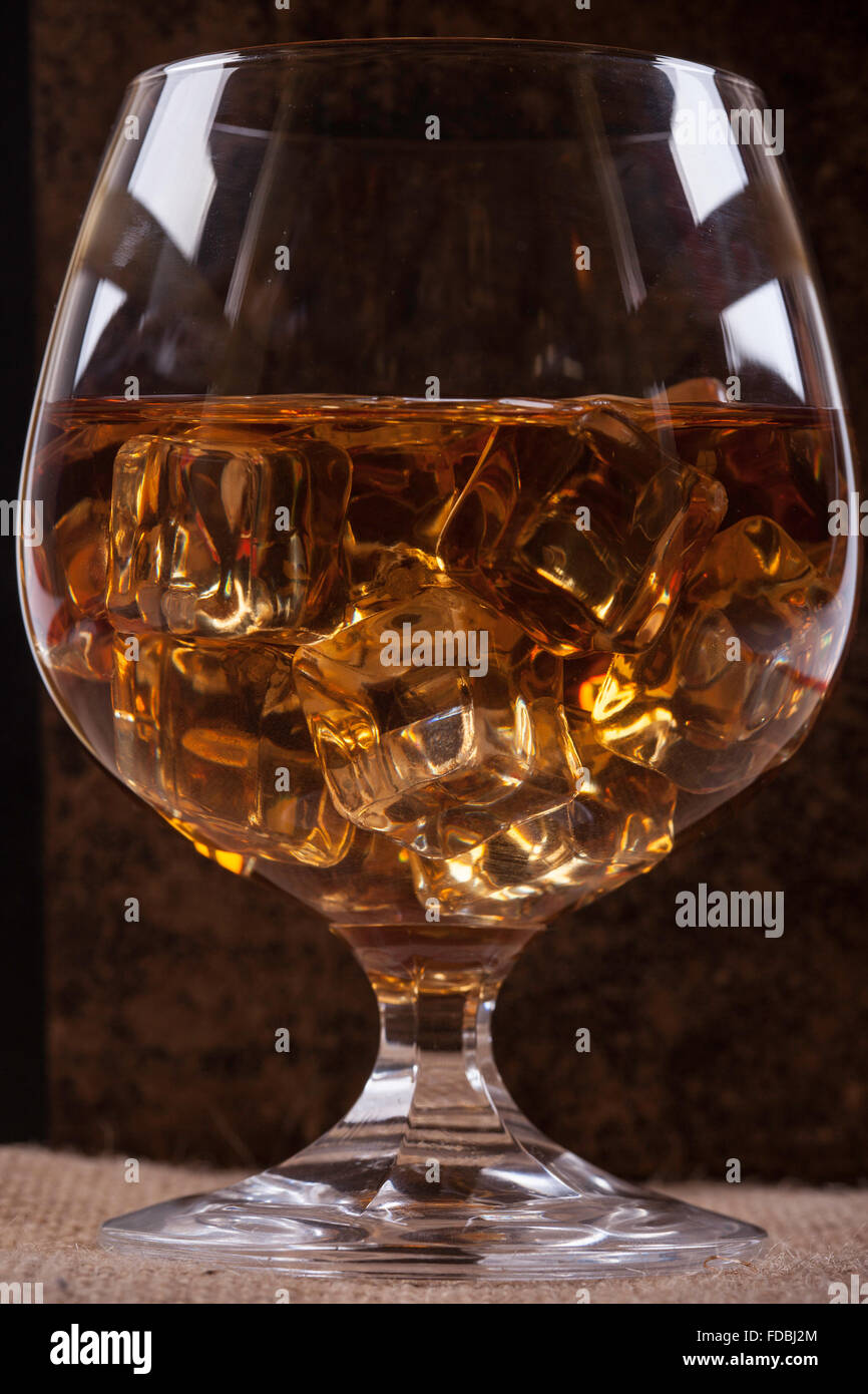 Verre de cognac avec de la glace arrière-plan gros plan Banque D'Images