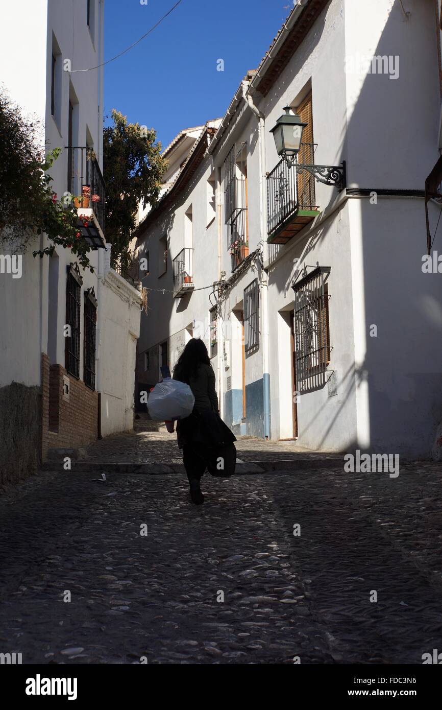 Dame marche à travers les rues de la vieille ville de Grenade, Espagne Banque D'Images