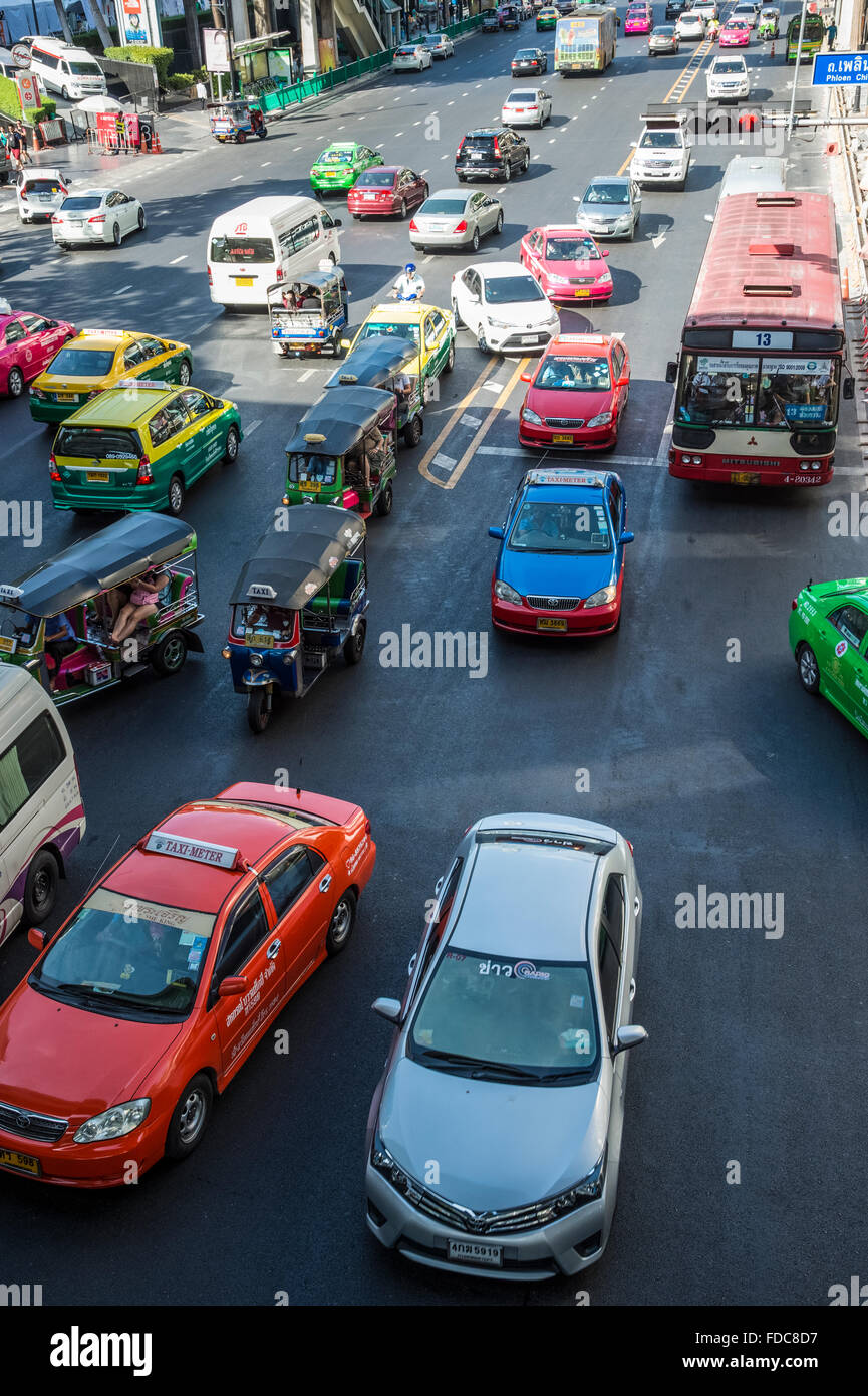 Scène de rue à Bangkok Ratchadamri Road avec un mélange de voitures, taxis et de l'omniprésent taxi Tuk-Tuk Banque D'Images