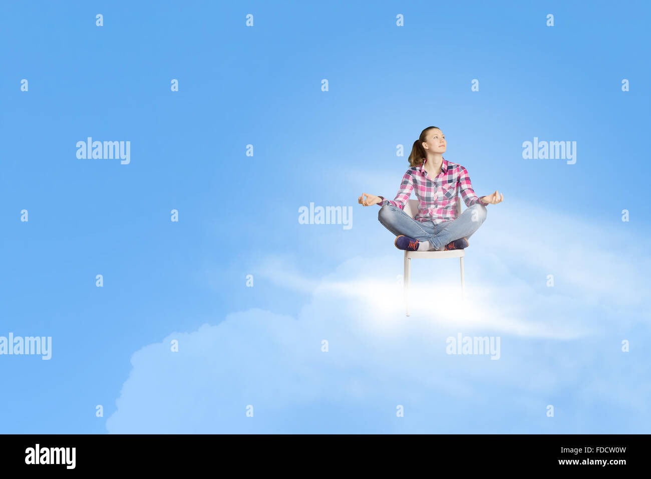 Jeune femme assise sur une chaise et méditant Banque D'Images