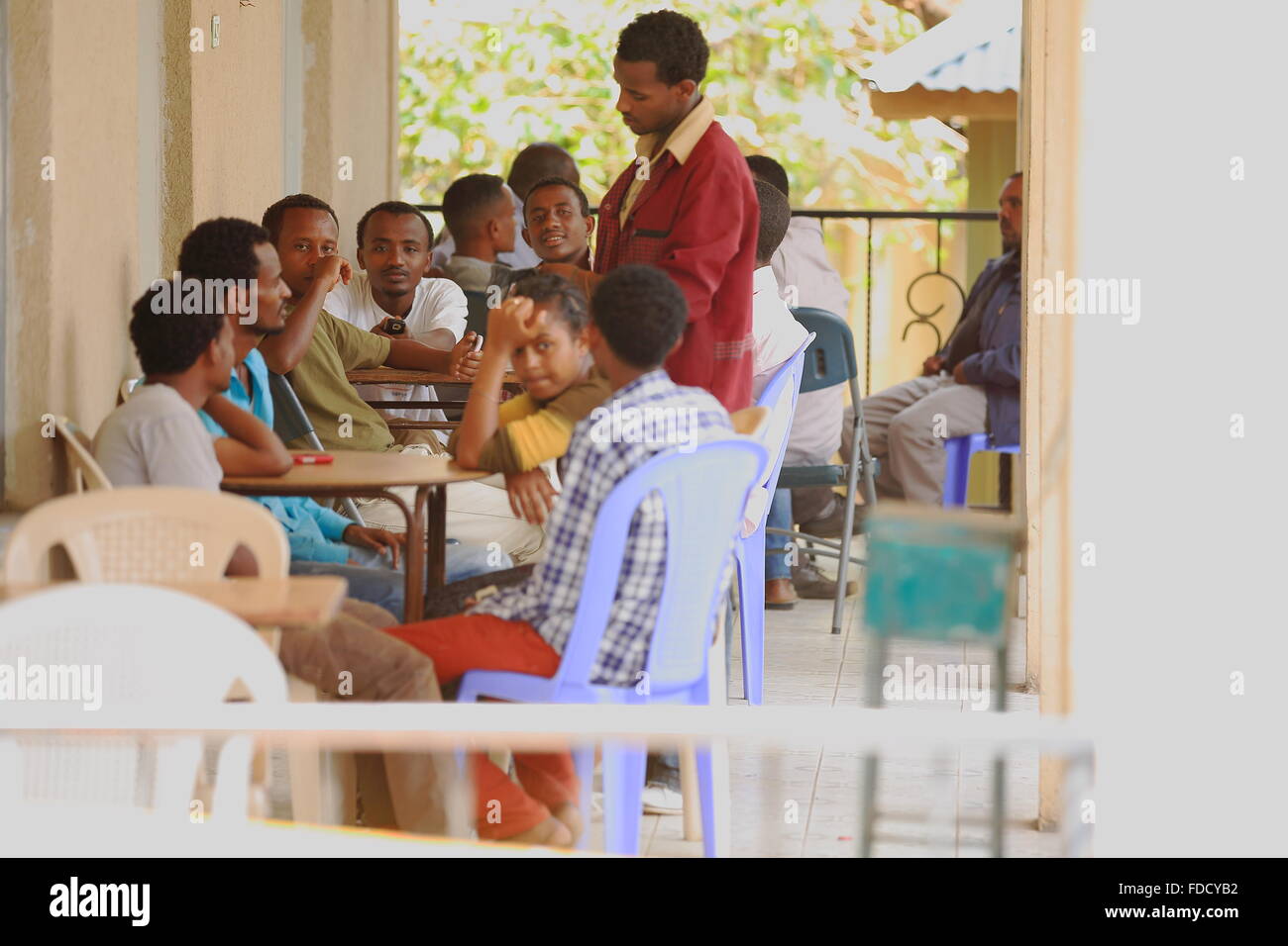 DEBRE BIRHAN, ÉTHIOPIE-MARS 24 : Les hommes de se réunir sur le porche d'un bar à côté de la route-waiter serving eux certains café local. Banque D'Images