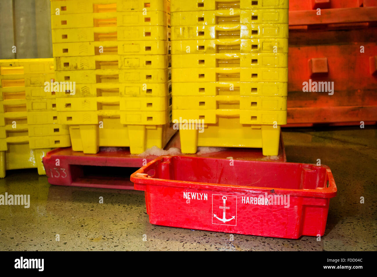 Caisses à poisson rouge et jaune au port de Newlyn Banque D'Images