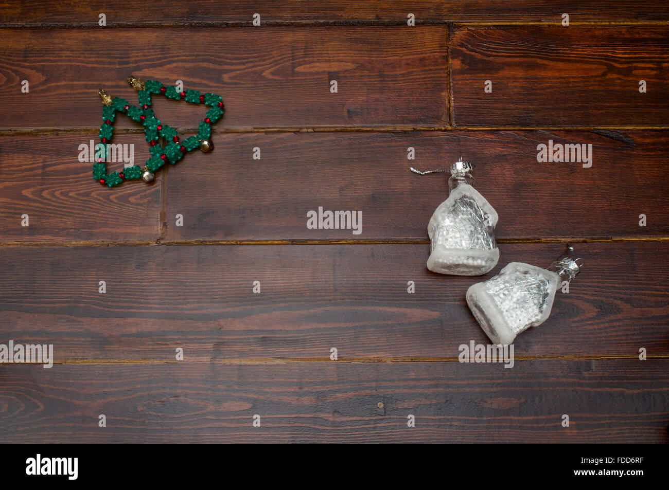 Arbre de Noël avec des cloches et des maisons de verre sur la table en bois Banque D'Images