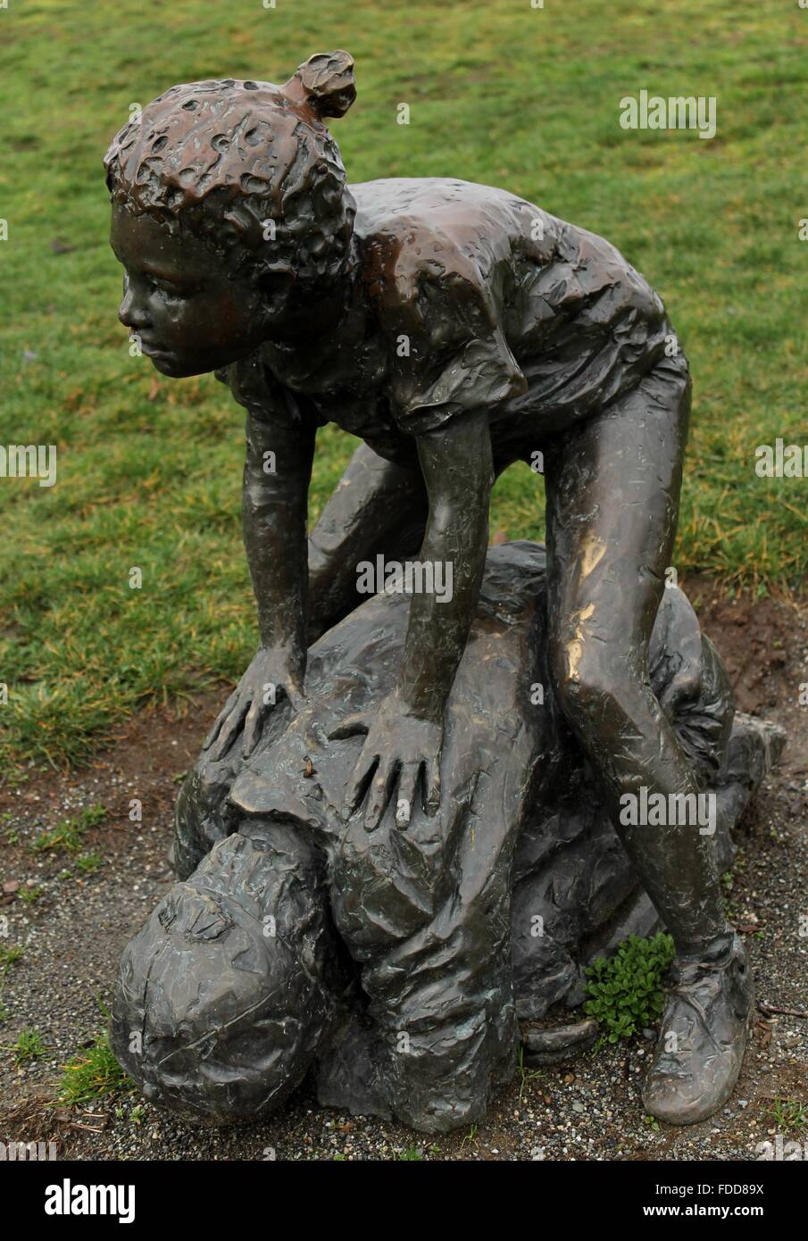 Statue en bronze d'enfants jouant dans un parc. Banque D'Images