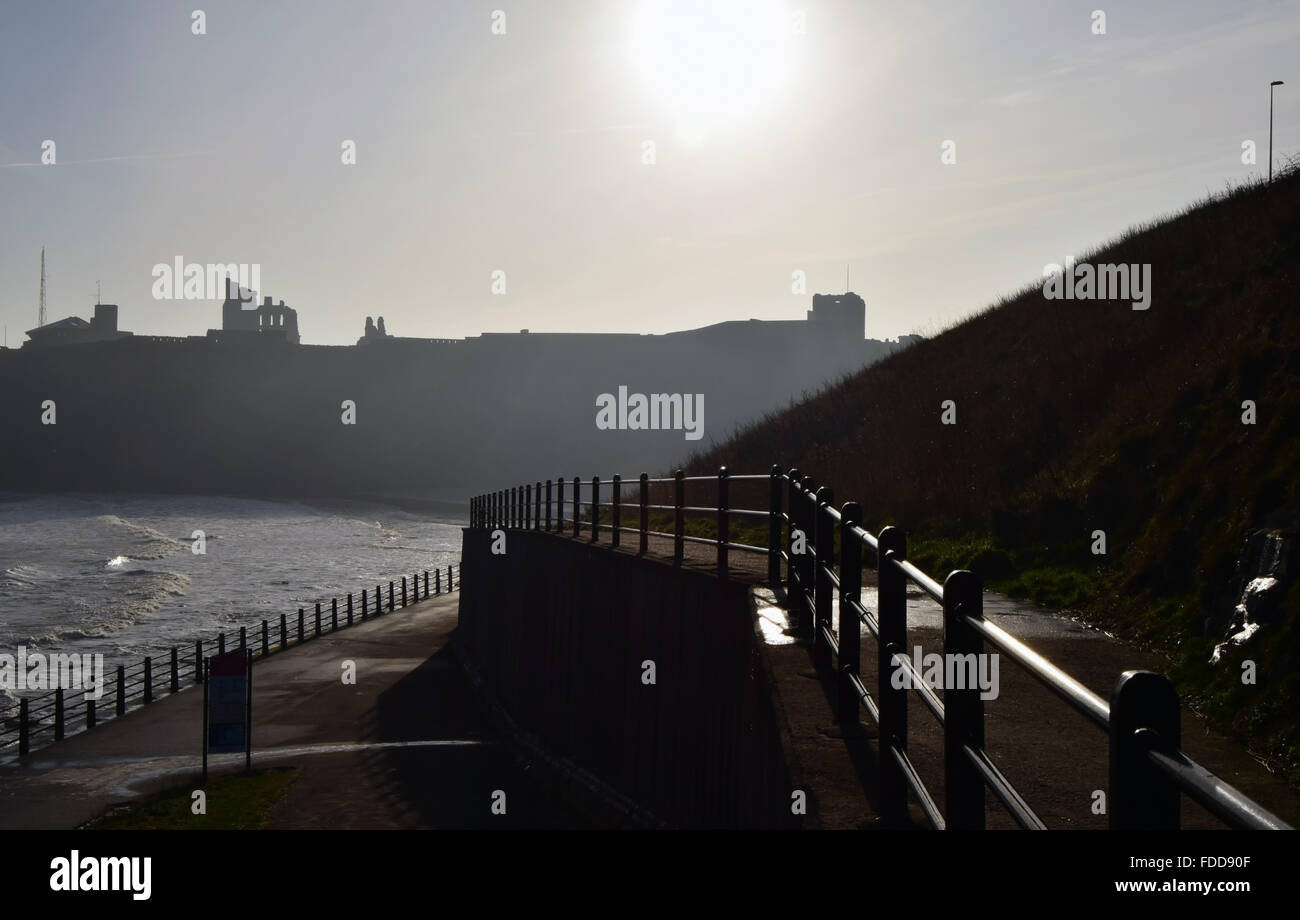 Tynemouth Priory en silhouette dans l'arrière-plan avec promenade et garde-corps à l'avant-plan Banque D'Images