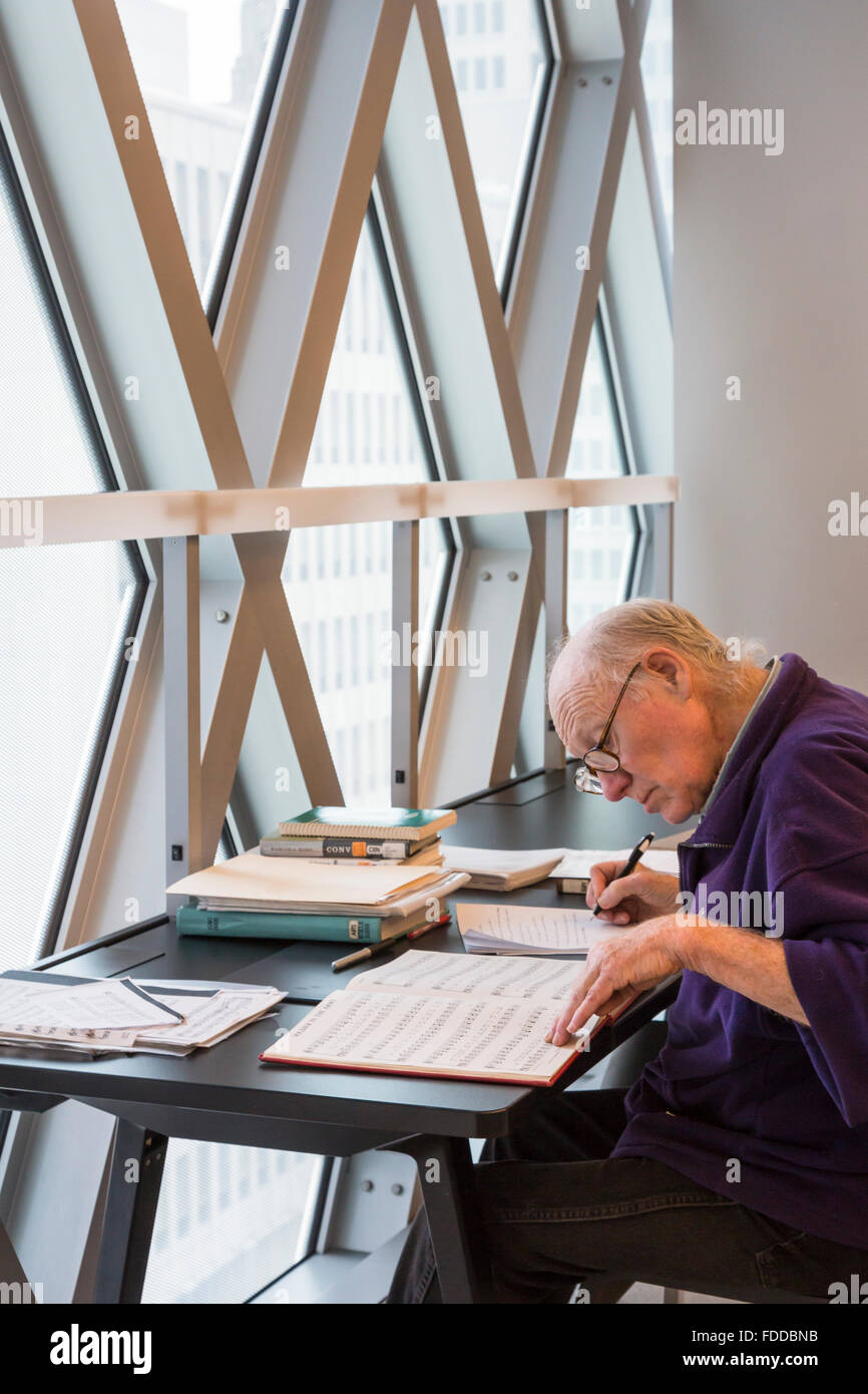 Man l'étude de partitions musicales dans le Seattle Central Library, conçu par les architectes Rem Koolhaas et Joshua Prince-Ramus Banque D'Images