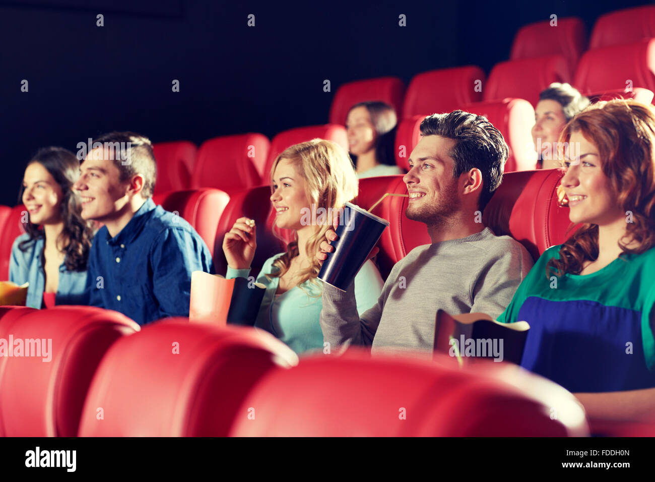 Happy friends watching movie in theatre Banque D'Images