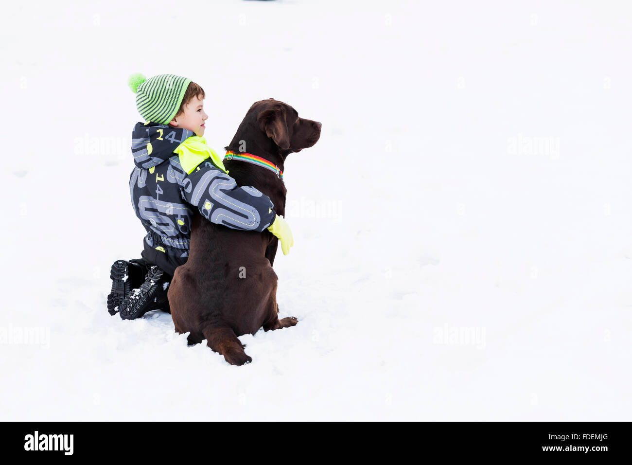 Enfant d'âge scolaire avec chien dans winter park Banque D'Images