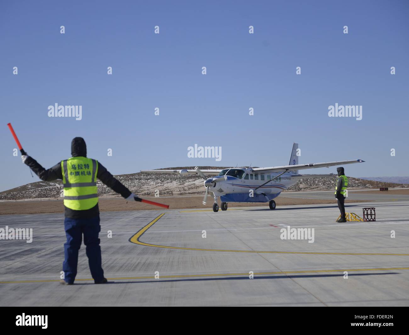 Bayannur, la Région autonome de Mongolie intérieure. Jan 31, 2016. Un travailleur de l'aéroport dirige un avion à l'aéroport général Urad Middle Banner dans Bayannur, Chine du nord, région autonome de Mongolie intérieure, le 31 janvier 2016. L'aéroport, l'un des 10 aéroports général de la Mongolie intérieure dans la région de cinq ans du 12e plan de l'aviation civile, a été ouverte à la circulation le dimanche. © Zhi Maosheng/Xinhua/Alamy Live News Banque D'Images