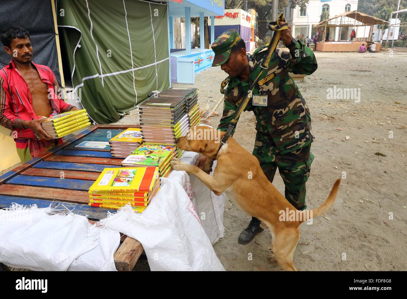 Dhaka, Bangladesh. 31 janvier, 2016. Le personnel de l'Armée livres chèques avec un chien dressé à la Foire du livre de Bangla Academy locaux à Dhaka, Bangladesh 31 janvier 2016. La sécurité a été mis en œuvre pour l'événement annuel qui débutera le 01 février avec des centaines d'étals de livres. Les Bangladais né écrivain américain-blogger Avijit Roy a été tué à son retour de la foire du livre en 2015. Banque D'Images