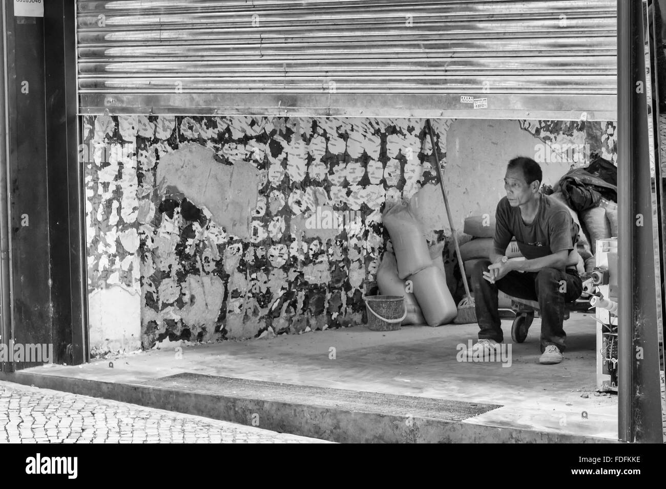 Un maçon reposant dans la cour à Macao, Chine. Banque D'Images