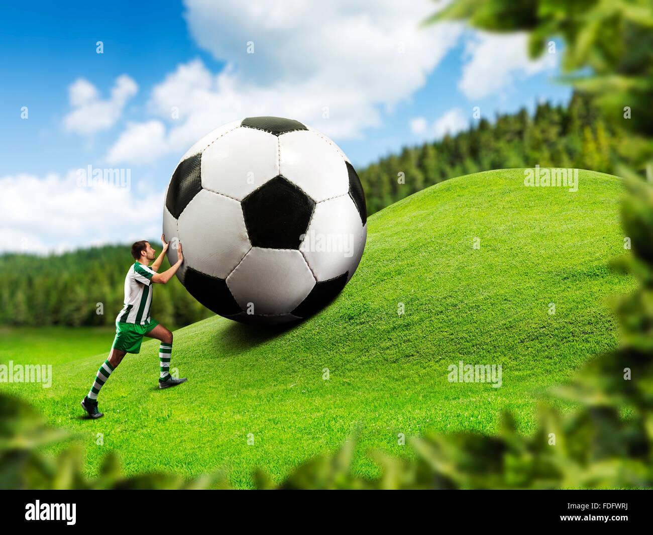 Football-player poussant une balle Banque D'Images