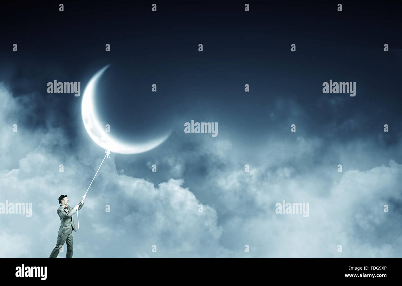 Young Woman in hat qui obtient la lune avec corde Banque D'Images Young Woman in hat qui obtient la lune avec corde Banque D'Images