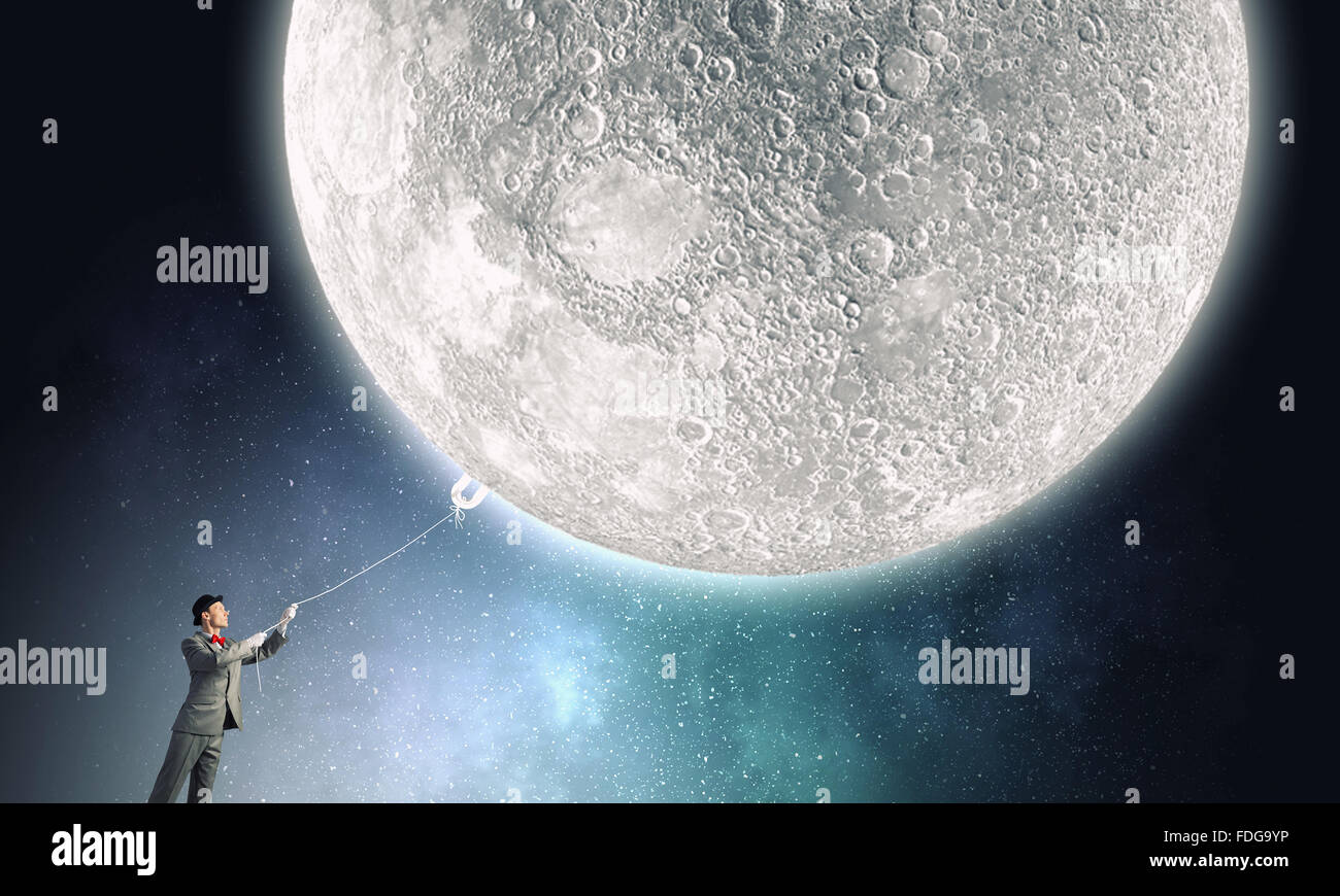 Young Woman in hat qui obtient la lune avec corde Banque D'Images Young Woman in hat qui obtient la lune avec corde Banque D'Images