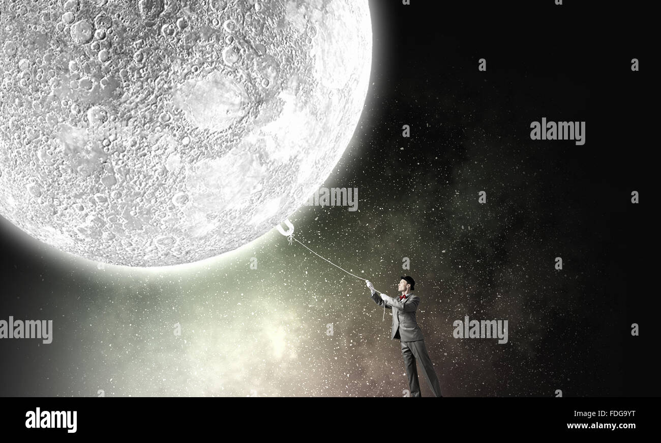 Young Woman in hat qui obtient la lune avec corde Banque D'Images Young Woman in hat qui obtient la lune avec corde Banque D'Images