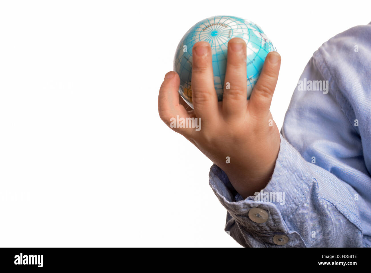 Bébé avec chemise bleue tenant un petit globe dans la main sur fond blanc Banque D'Images