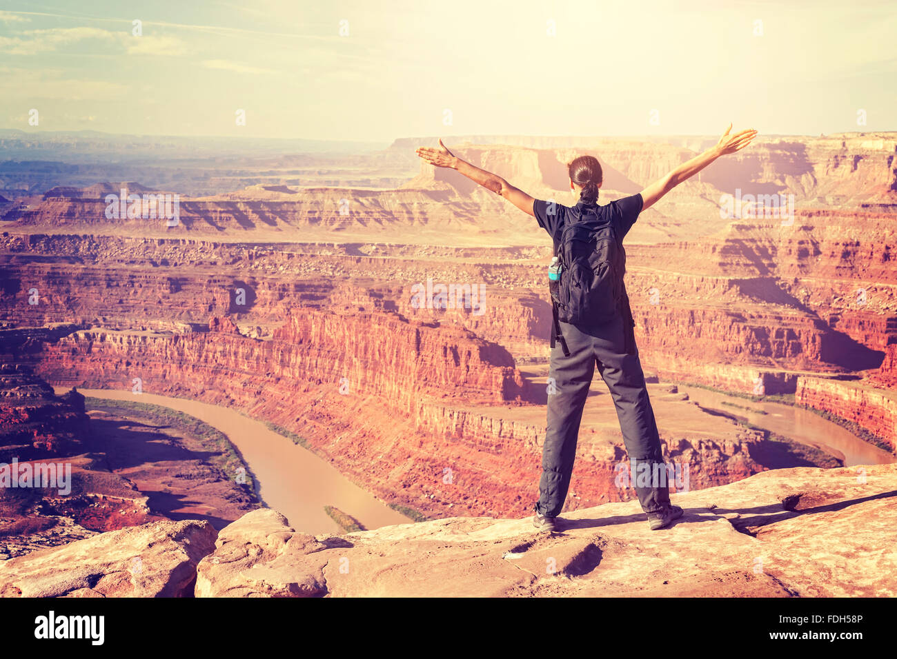 Tons Vintage femme debout sur une falaise avec les mains en l'air, USA. Banque D'Images