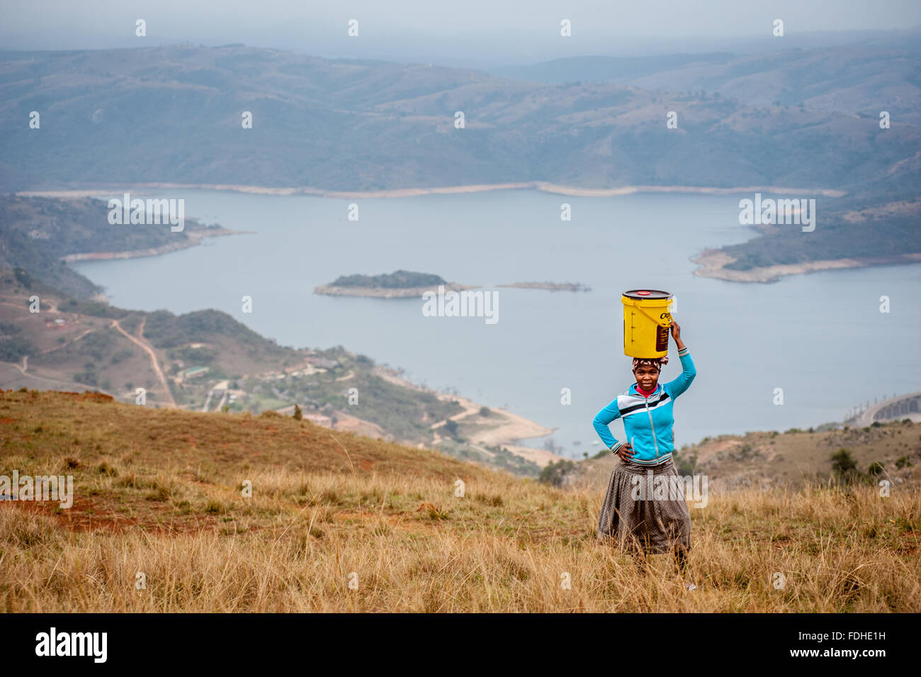 Femme portant un seau sur la tête dans la région de Hhohho Swaziland, Afrique. Banque D'Images