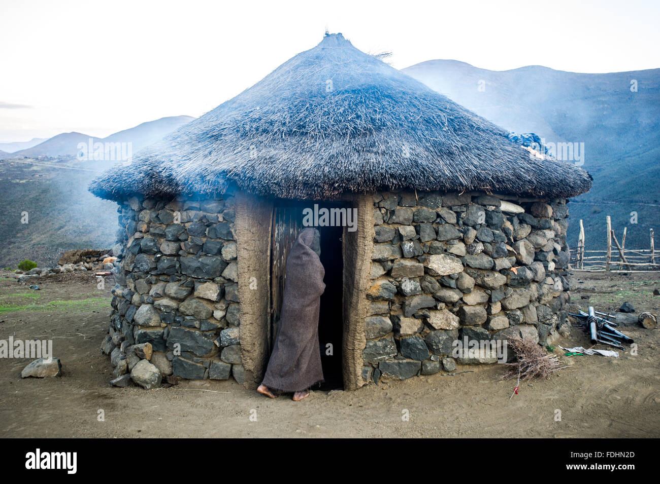 Jeune garçon aux portes d'un village hut au Lesotho, l'Afrique Banque D'Images