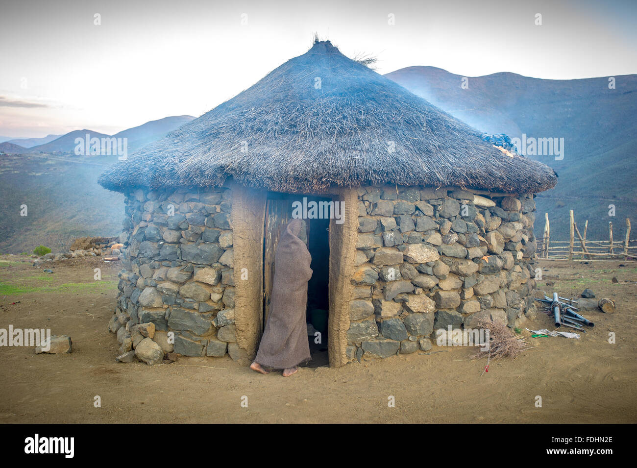 Jeune garçon aux portes d'un village hut au Lesotho, l'Afrique Banque D'Images