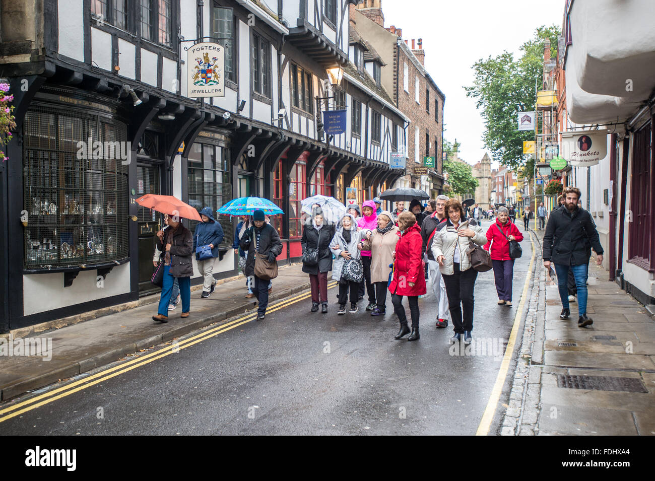 Les touristes passent dans la rue dans la ville de York dans Yorkshire, Angleterre, Royaume-Uni. Banque D'Images