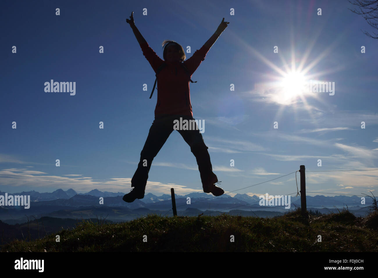 Sauter de joie de la randonnée dans les collines de l'emmental avec Alpes bernoises en retour, Suisse Banque D'Images